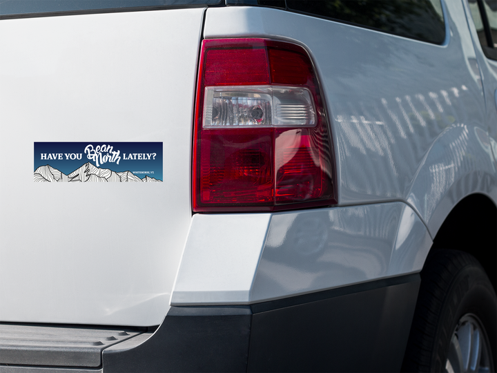 Bumper sticker with text and mountain graphic on a car&